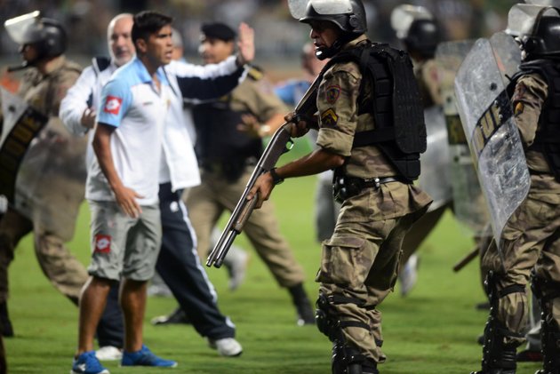 Foto Arsenal pelea con policía brasileña, policía brasileña punta la pistola contro Arsenal